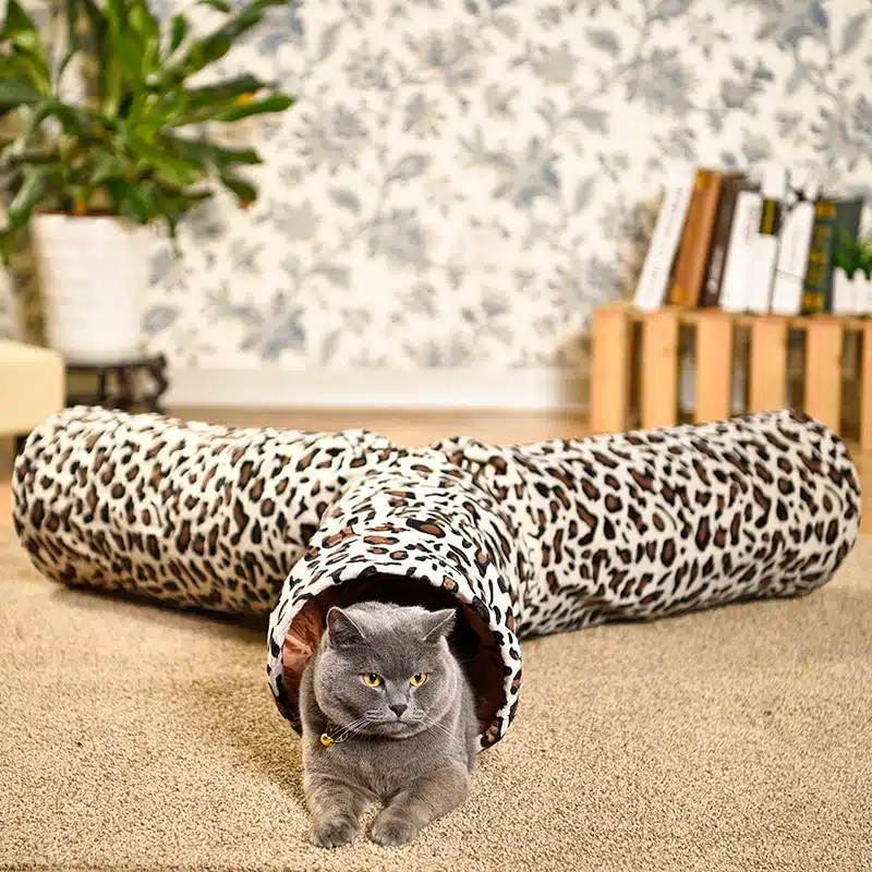 Tunnel imprimé léopard pour chat avec un chat gris à l'intérieur dans une maison