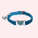 Collier en cuir avec cloche pour chat de couleur bleu avec un coeur bleu brillant. Sur fond rose.