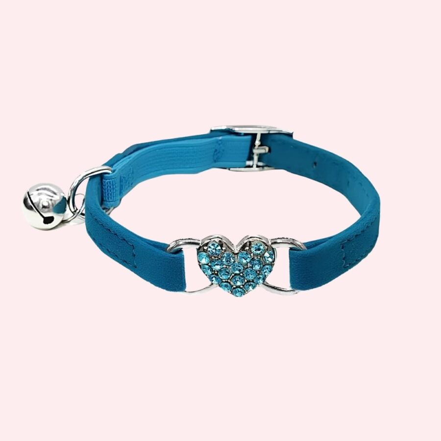 Collier en cuir avec cloche pour chat de couleur bleu avec un coeur bleu brillant. Sur fond rose.