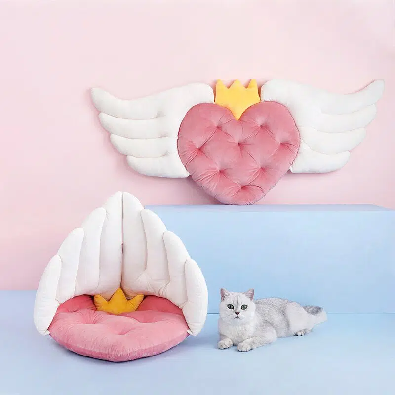 Coussin forme aile d'ange pour chat avec un chat sur un canapé dans une maison