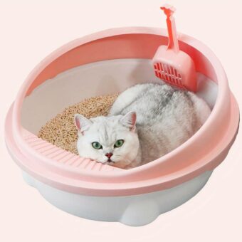 Litière chat rond en plastique avec pelle rose et blanc avec un chat à l'intérieur dans une maison