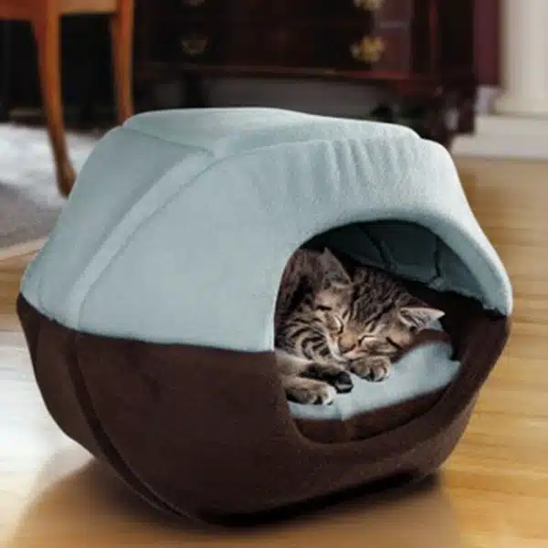 Niche chaude en forme de grotte pour chat très confortable de couleurs blanc et marron avec un chat à l'intérieur dans une maison
