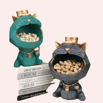 Statue chat à grande bouche gris et vert sur une table dans une maison