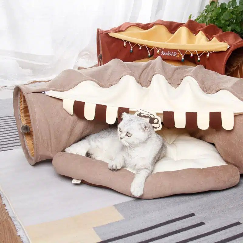 Tunnel de lit pliable et amovible pour chat marron sur un tapis dans une maison