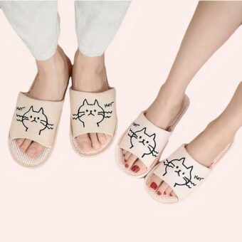 deux paires de pantoufles rose clair avec des têtes de chats dessinées