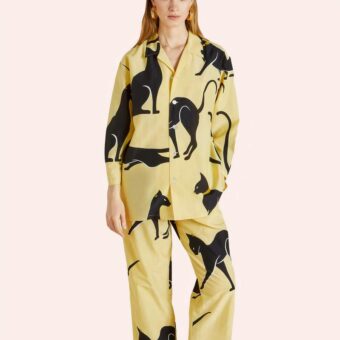 Femme portant un pyjama jaune avec motif de chats