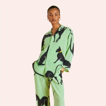 Femme portant un pyjama vert avec motif de chats