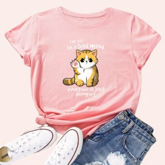 Tee shirt rose avec petit chat roux dessiné, paire de tennis et de jean à cote