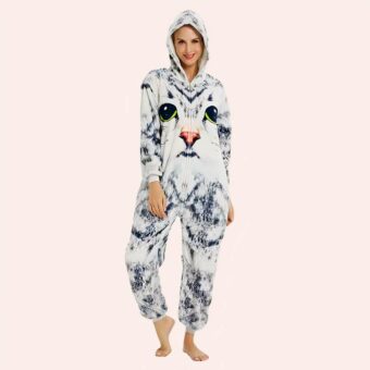 Une femme debout en combinaison imprimé chat gris et blanc sur fond blanc.