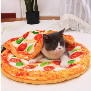 chat noir et blanc se trouvant sur un couchage pour chat représentant un visuel d'une pizza , et par dessus lui, un couverture dans le même motif