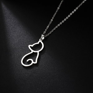 présenté sur fond noir, un collier argenté en acier inoxydable avec un pendentif d'un petit chat mignon