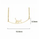 pendentif de collier argenté d'un chat qui marche en équilibre , présenté sur fond noir
