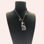 sur un mannequin pour collier noir, un collier en métal avec un pendentif de chat élégant et fier, avec de jolis détails est présenté