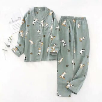 présenté à plat et sur fond blanc, un pyjama rose avec des motifs de petits chat, il est composé d'un haut en chemise à manche longue et d'un pantalon