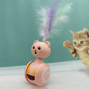 Chaton tigré jouant avec le jeu roulant et rotatif rose à plumes