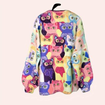 Pull large doux avec motifs chats multicolore présenté sur fond noir