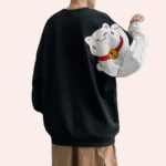 Pull large noir avec motif de chat blanc dessin animé porté pas une personne de dos dont on ne voit pas la tête