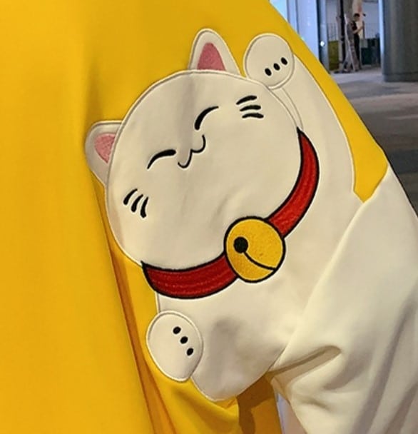 Pull large jaune avec motif de chat blanc dessin animé