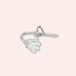 Bague ouverte patte de chat pour femmes posée sur un support blanc et brillant