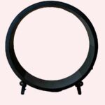 Roue pour chat en PVC noir, ayant comme socle 4 roues permettant de la déplacer. Elle est posée au sol sur un parquet, le mur est en bois clair