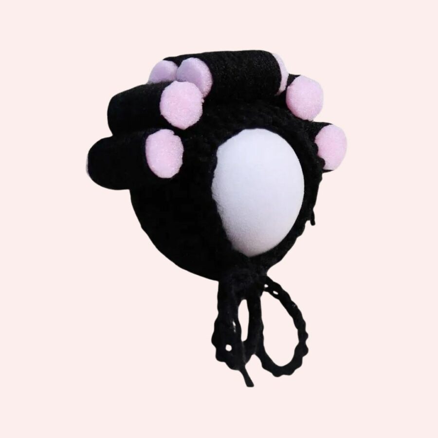 Bonnet perruque avec bigoudis roses sur support à chapeau sur fond rose.