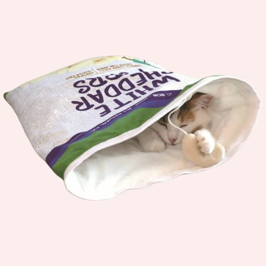 Sac de couchage en forme d'emballage de paquet de chips avec un chat blanc dedans sur un fond rose