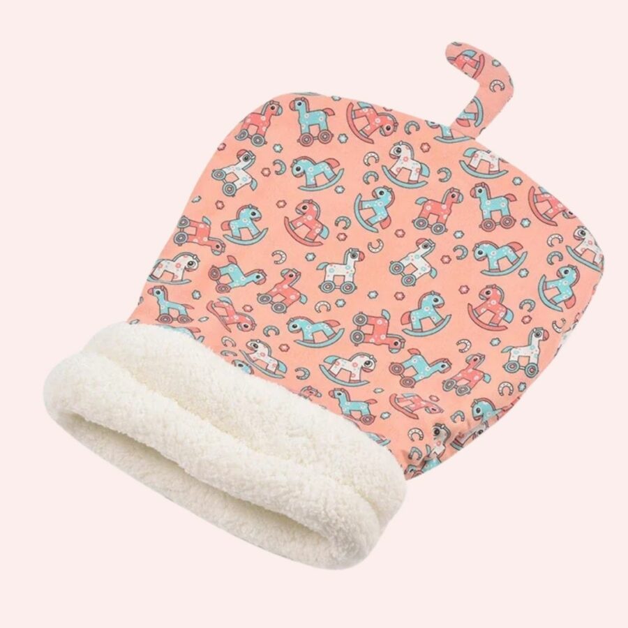 Sac de couchage rose avec motifs cheval à bascule sur fond rose