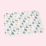 Un tapis rafraichissant chat motif dinosaures mignons blanc, avec de petits dinos verts et des empreintes orange, posé sur un fond rose clair.