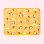 Un tapis rafraichissant chat orange avec motif et carottes, jaune, décoré de petits chats et de carottes, posé sur un fond rose clair.