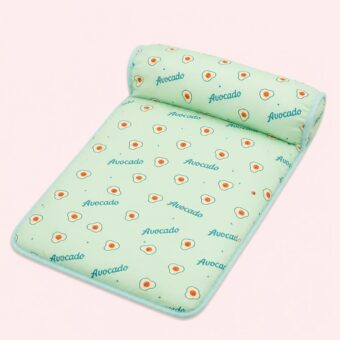 Homepage Un tapis rafraichissant chat en soie glacée pour dissiper la chaleur vert menthe, avec un motif d’avocats, posé sur un fond rose clair.